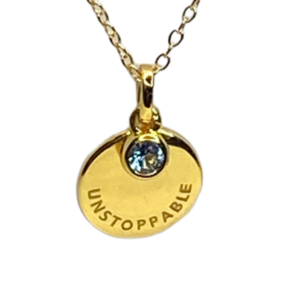 Elegant gold pendant necklace with a motivational 'Unstoppable' engraving and a sparkling gemstone, designed to inspire confidence and success.