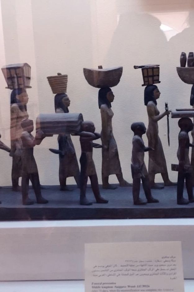 An ancient Egyptian funeral procession artifact displayed at the Cairo Museum, showcasing a detailed representation of cultural traditions.