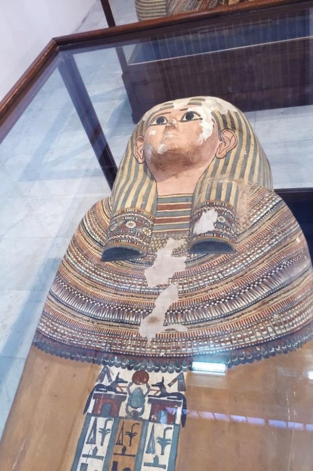An ancient Egyptian sarcophagus on display at the Cairo Museum, showcasing detailed artwork and historical significance.