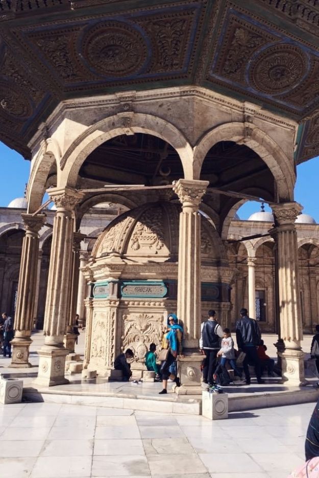 Intricate architectural details of the Mohammed Ali Mosque in Cairo, Egypt, with visitors admiring the historic structure.
