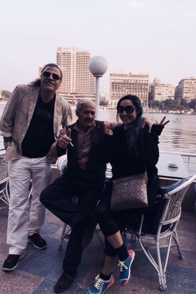 A couple posing with a local man by the Nile River in Cairo, Egypt, capturing a friendly and memorable encounter.