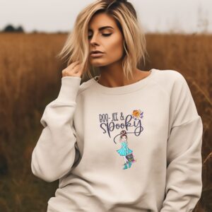 A model wearing our sandstone 'Boojee and Spooky' Halloween sweatshirt with a chic pumpkin and spooky girl design.