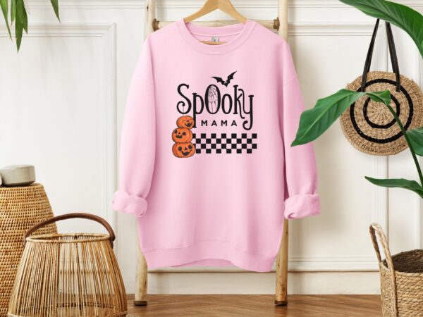 A Classic Pink "Spooky Mama" Sweatshirt featuring a pumpkin design, perfect for expressing your unique style.