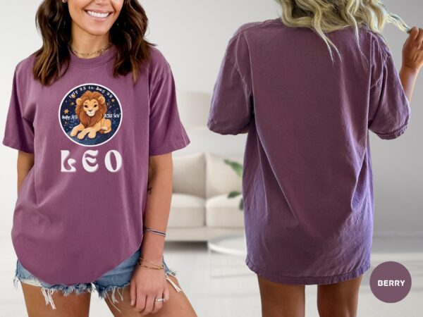 Woman wearing a Berry Comfort Colors 1717 t-shirt with a Leo Zodiac design featuring a cute lion illustration, stars, and the dates "July 23 to Aug 22."