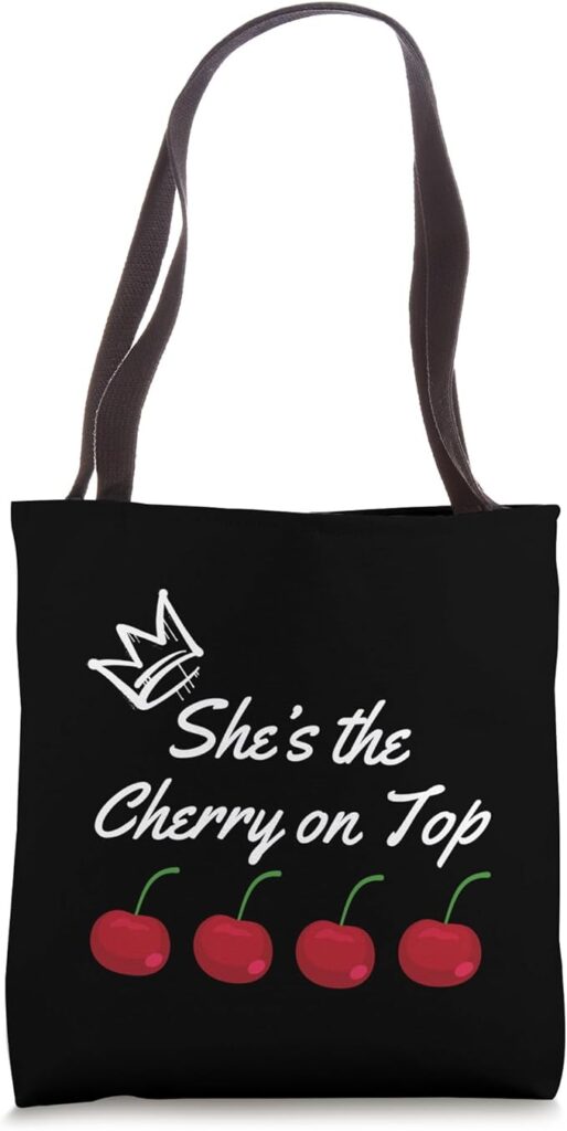 Stylish black tote bag with cherry design and 'She’s the Cherry on Top' text—perfect for trendy fashion lovers.