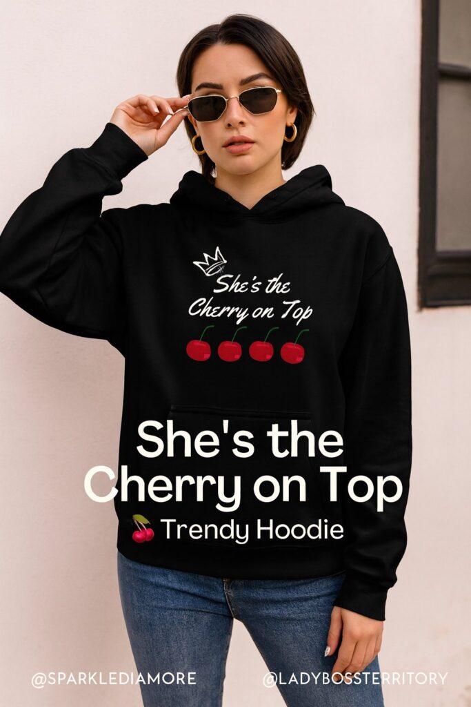 Stylish woman wearing black hoodie with “She’s the Cherry on Top” cherry graphic – trendy cherry fashion streetwear.
