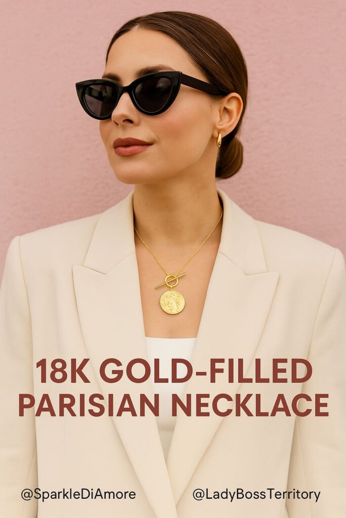 Elegant woman wearing an 18K gold-filled Parisian necklace with a round medallion pendant, paired with a cream blazer for a timeless and chic look
