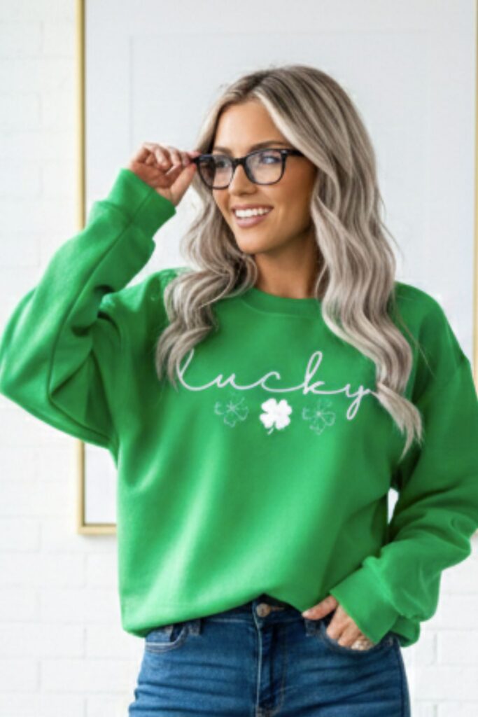 Woman wearing a green Lucky Clover St Patrick’s Day Sweatshirt with a white lucky four leaf shamrock design.