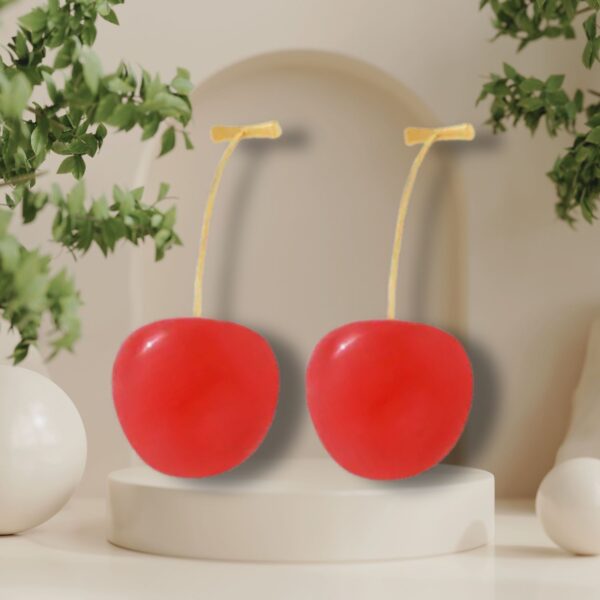 Cherry drop earrings displayed in natural light with greenery decor