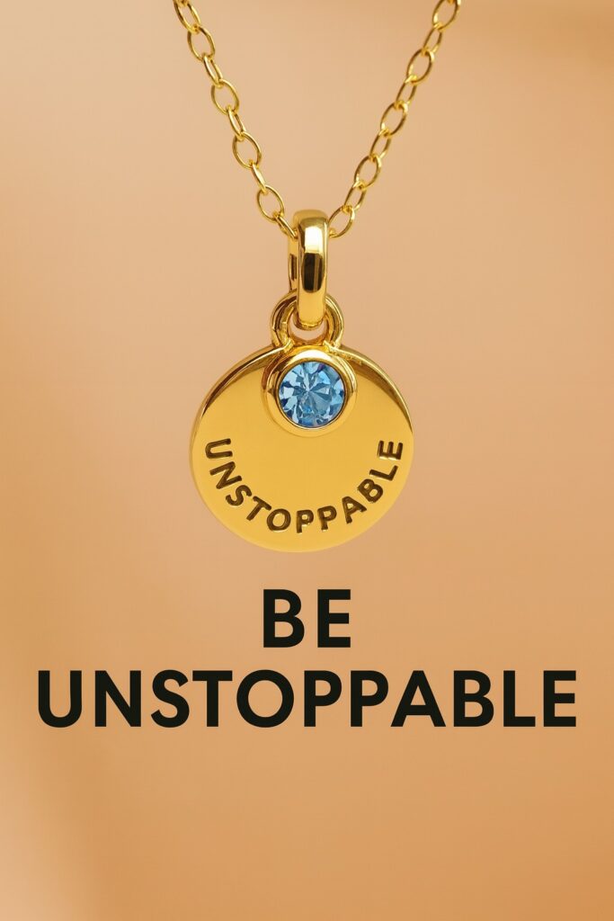 Gold “Unstoppable” necklace with blue gemstone symbolizing confidence, empowerment, and manifestation energy.